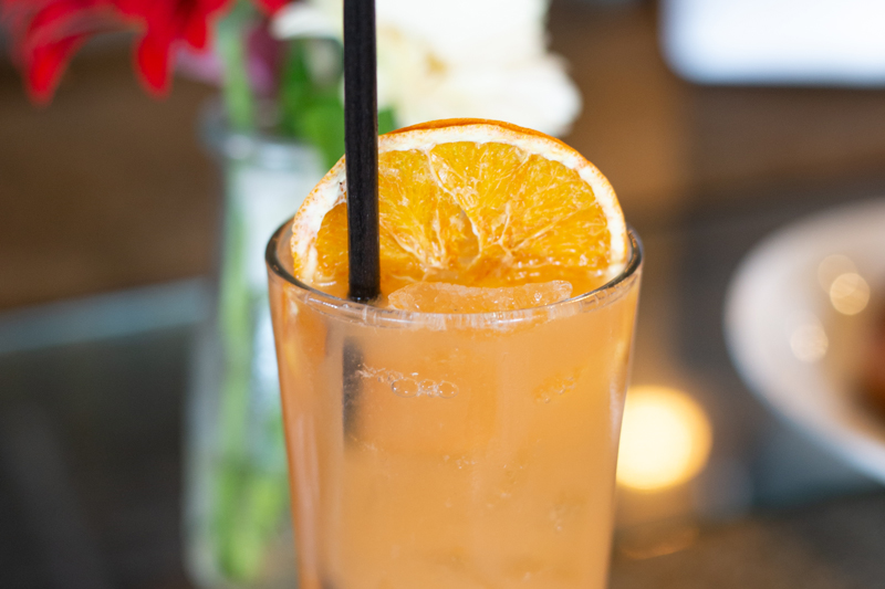Close up on a light orange cocktail.